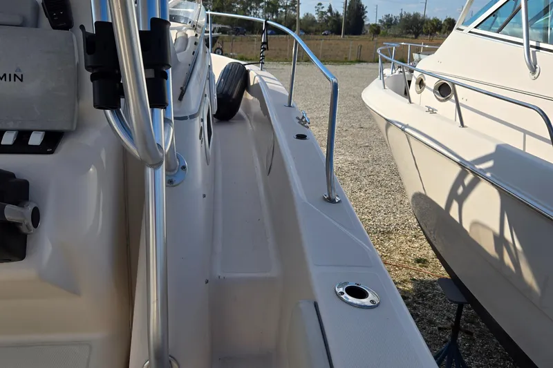Slide: The Image of 2008 Cobia 316 Sport Cabin boat docked, showcasing side deck and railing. - 16
