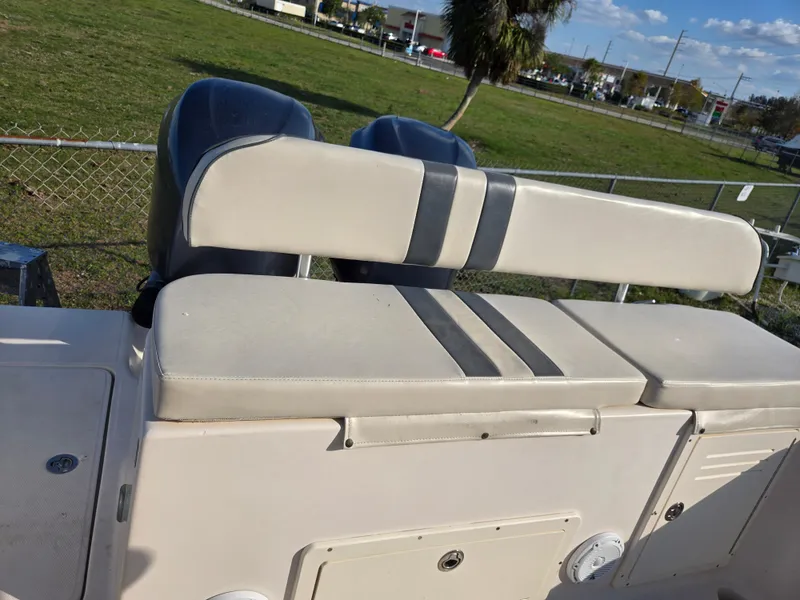 Slide: The Image of 2008 Cobia 316 Sport Cabin boat seat with dual engines in a grassy area. - 18