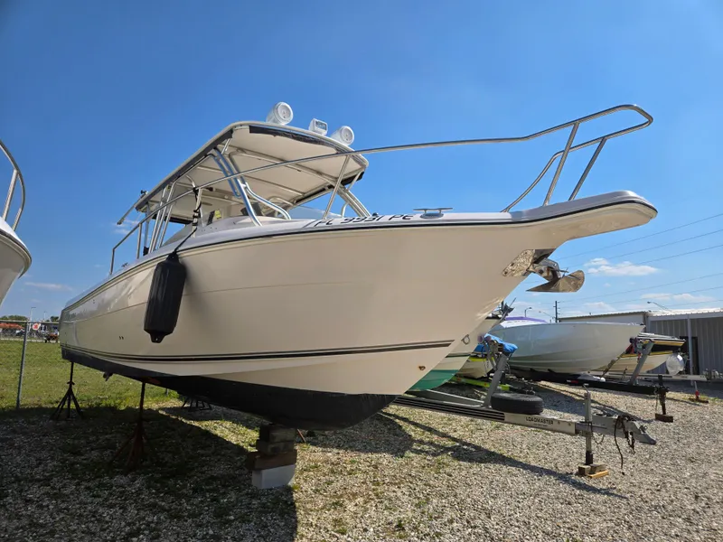 Slide: The Image of 2008 Cobia 316 Sport Cabin boat on dry dock under clear blue sky. - 2