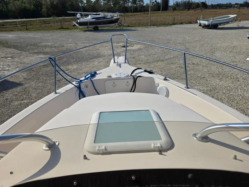Slide: The Image of 2008 Cobia 316 Sport Cabin boat, front deck view, parked on gravel lot. - 20