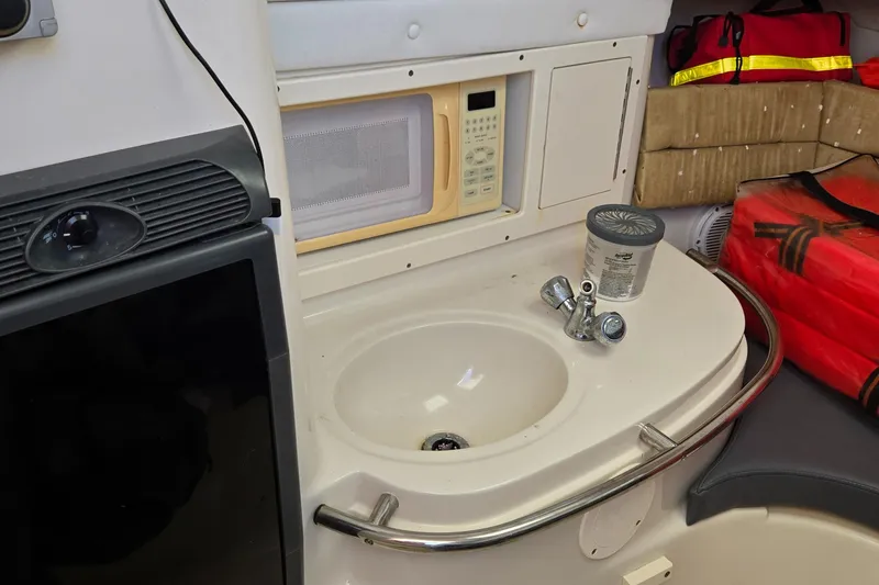 Slide: The Image of Interior of 2008 Cobia 316 Sport Cabin with sink, microwave, and storage. - 25