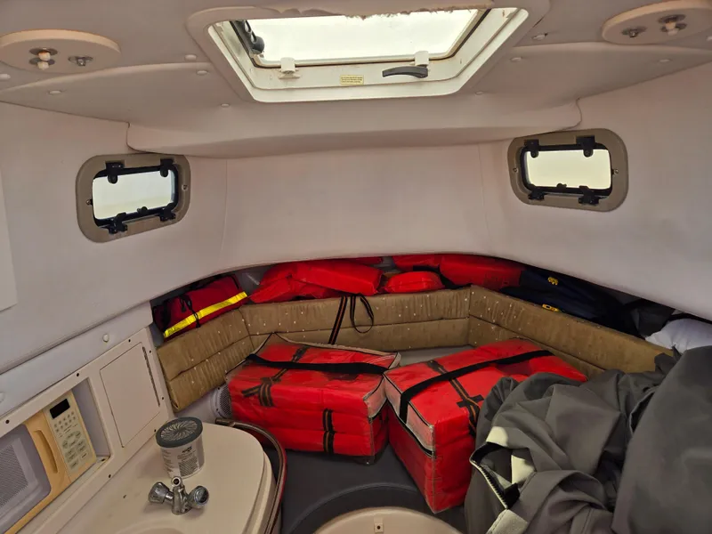 Slide: The Image of Interior of 2008 Cobia 316 Sport Cabin with red life jackets and portholes. - 26