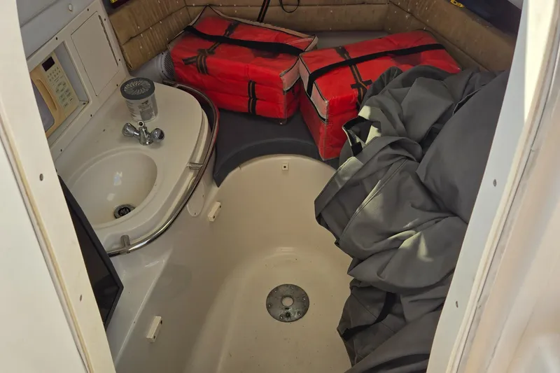 Slide: The Image of 2008 Cobia 316 Sport Cabin interior with sink, life jackets, and storage area. - 27