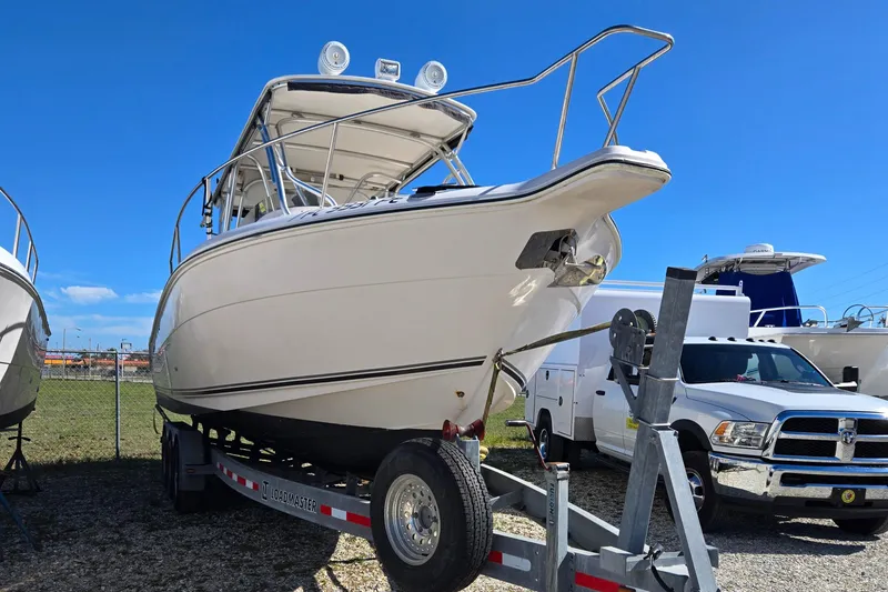 Slide: The Image of 2008 Cobia 316 Sport Cabin boat on trailer under clear blue sky. - 3