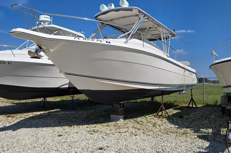 Slide: The Image of 2008 Cobia 316 Sport Cabin boat on stands, displayed outdoors under clear blue sky. - 4