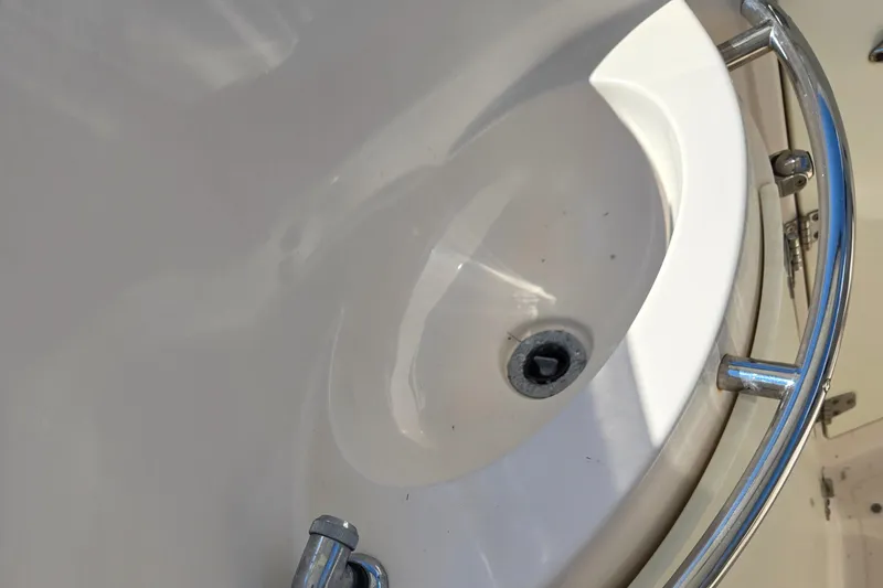 Slide: The Image of Close-up of a 2008 Cobia 316 Sport Cabin boat's sink with metal railing. - 43
