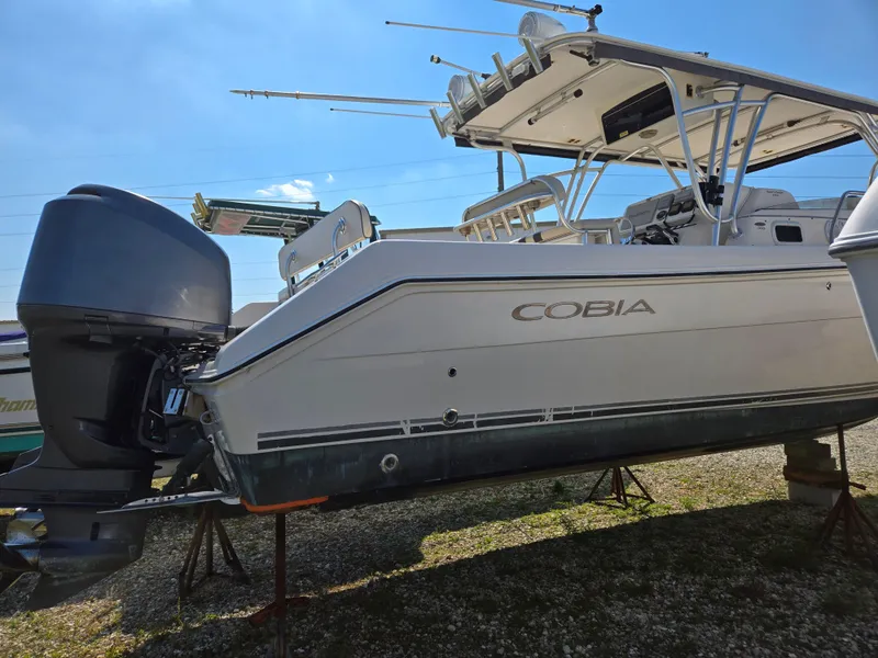 Slide: The Image of 2008 Cobia 316 Sport Cabin boat on stands, side view, clear sky background. - 5