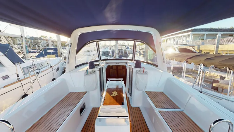 The Image of 2019 Beneteau Oceanis 38.1 yacht cockpit with wooden seating and canopy. - 0