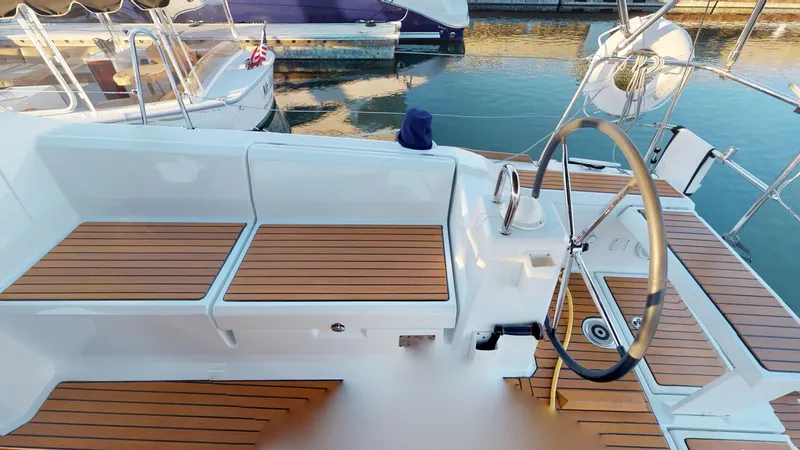 Slide: The Image of 2019 Beneteau Oceanis 38.1 yacht cockpit with teak seating and steering wheel. - 16