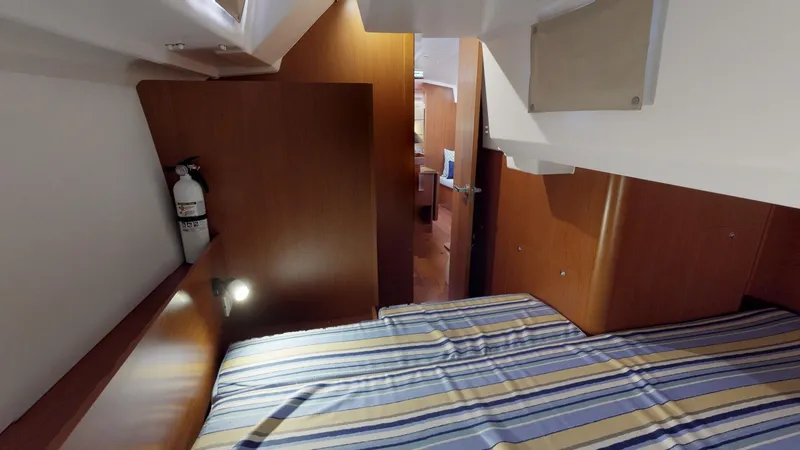 Slide: The Image of Cozy cabin interior of 2019 Beneteau Oceanis 38.1 with striped bedding and wooden finish. - 18