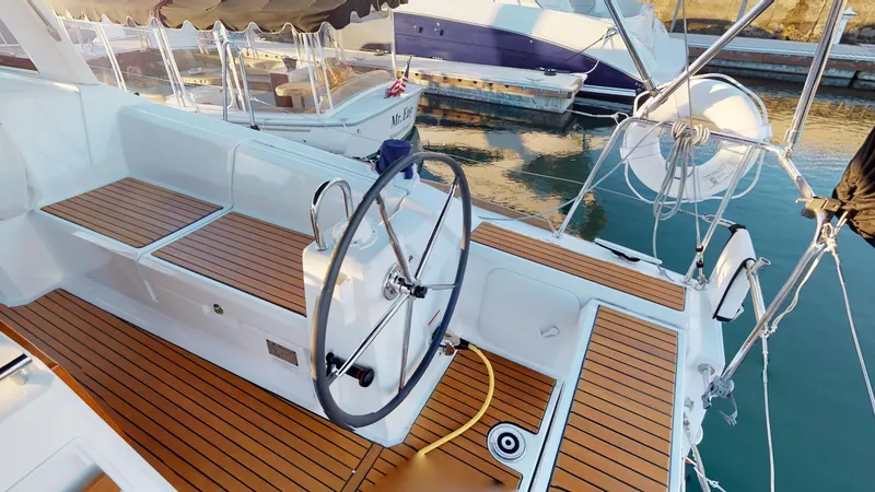 Slide: The Image of 2019 Beneteau Oceanis 38.1 yacht cockpit with teak flooring and steering wheel. - 2