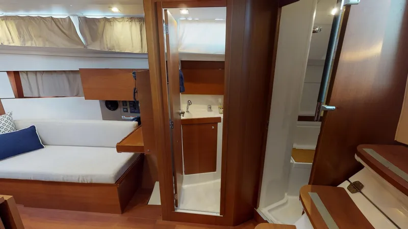 Slide: The Image of Interior of 2019 Beneteau Oceanis 38.1 yacht, featuring cozy seating and compact bathroom. - 22