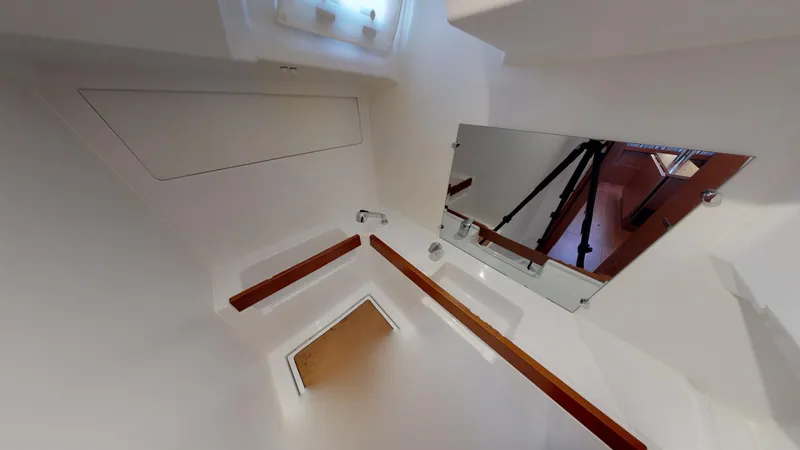 Slide: The Image of Interior of 2019 Beneteau Oceanis 38.1 yacht, featuring sleek white design and mirror. - 23