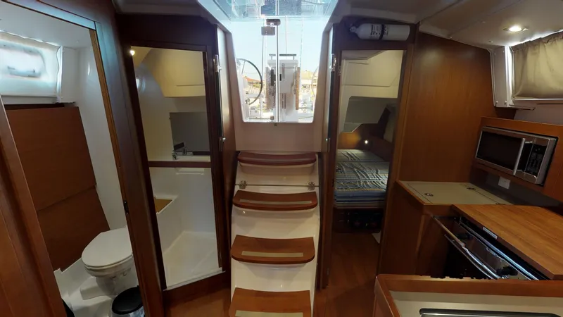 Slide: The Image of Interior of 2019 Beneteau Oceanis 38.1 yacht, featuring stairs, cabin, and kitchenette. - 26