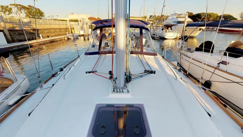 Slide: The Image of 2019 Beneteau Oceanis 38.1 sailboat docked in a marina, showcasing deck and mast. - 33