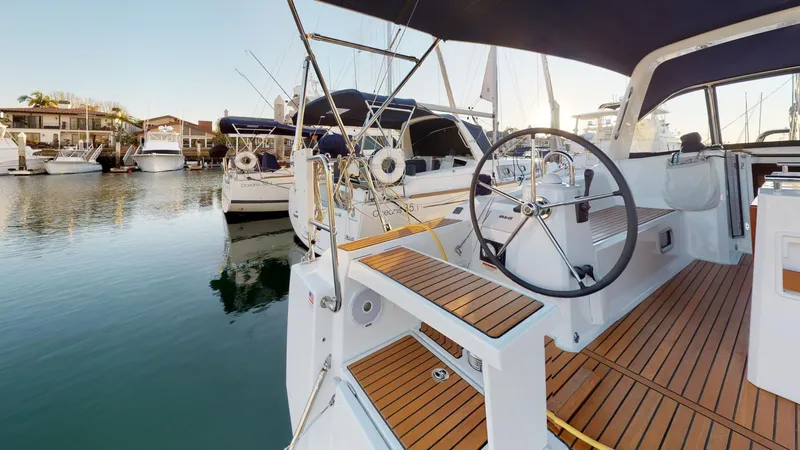 Slide: The Image of 2019 Beneteau Oceanis 38.1 sailboat docked in a marina, featuring a sleek deck design. - 36