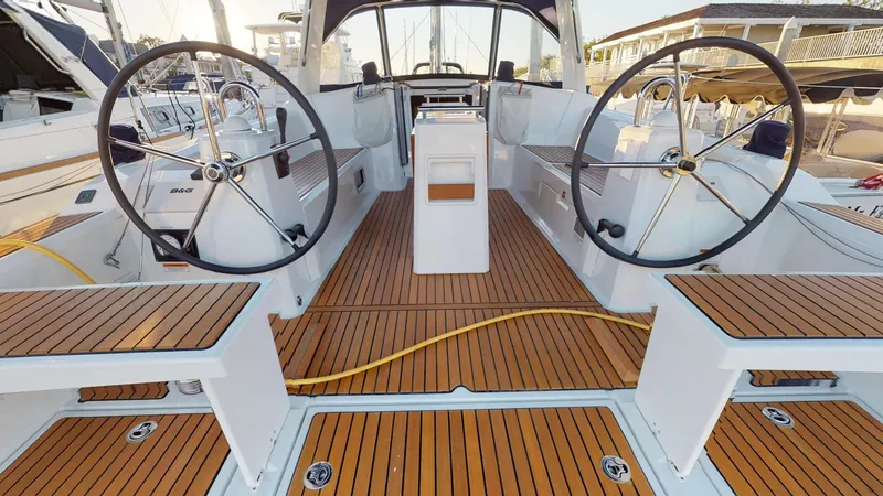 Slide: The Image of 2019 Beneteau Oceanis 38.1 yacht cockpit with dual steering wheels and teak flooring. - 4
