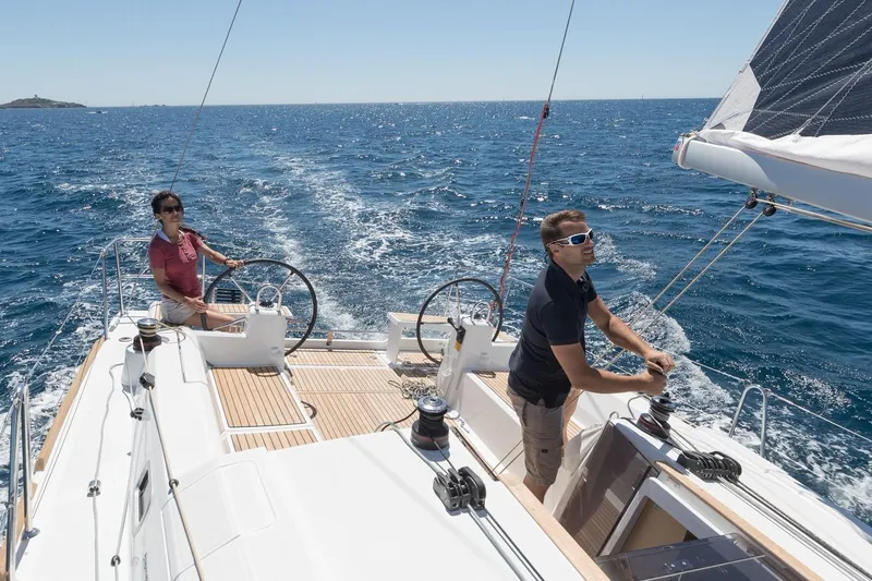 Slide: The Image of Two people sailing a 2019 Beneteau Oceanis 38.1 on open water. - 42