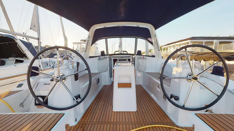 Slide: The Image of 2019 Beneteau Oceanis 38.1 yacht cockpit with dual steering wheels and teak flooring. - 5