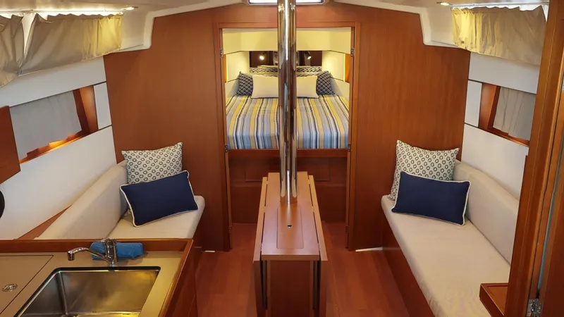Slide: The Image of Interior of 2019 Beneteau Oceanis 38.1 yacht with cozy seating and striped bedding. - 8