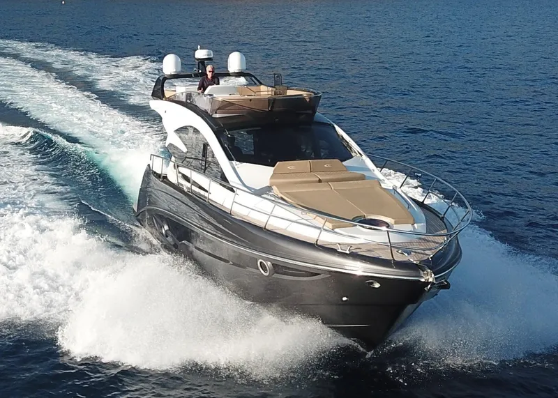 Slide: The Image of 2025 Cobrey 52 FLY yacht cruising on open water, showcasing sleek design and luxury features. - 2