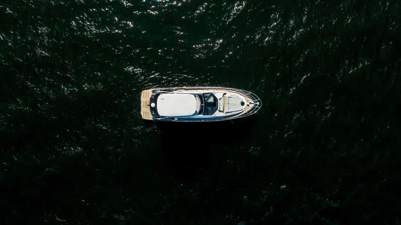 Slide: The Image of Aerial view of 2025 Cobrey 52 FLY yacht on dark water. - 8