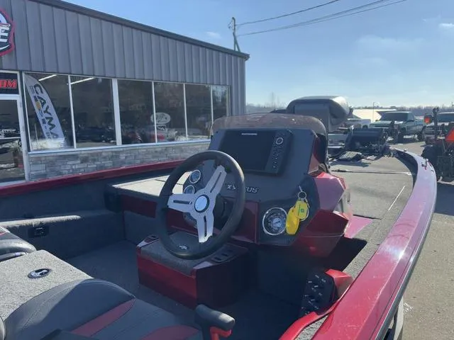 Slide: The Image of 2022 Venus AVX 1880 boat interior with steering wheel and dashboard, parked outside a showroom. - 4