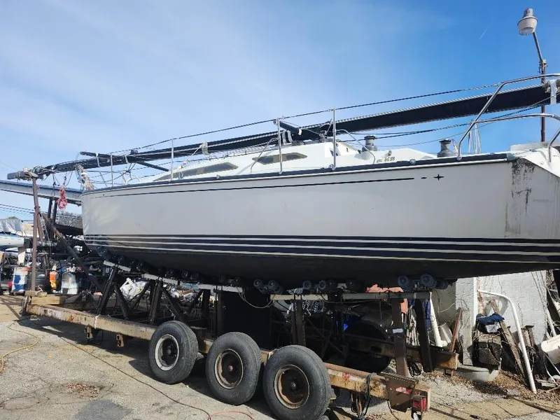 Slide: The Image of Sailboat on trailer, C&C 99 model, 2002, in a boatyard under clear sky. - 12