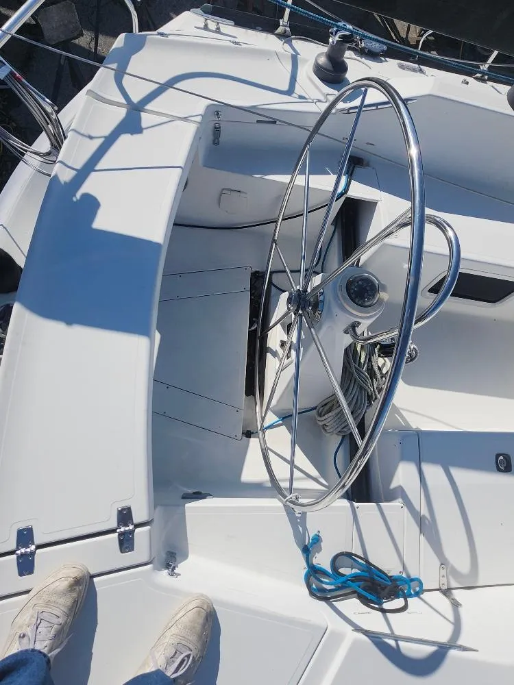 Slide: The Image of Steering wheel and cockpit of a 2002 C&C 99 sailboat, featuring clean white surfaces. - 21