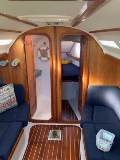 Slide: The Image of Interior of a 2002 C&C 99 sailboat with wooden finish and blue seating. - 3