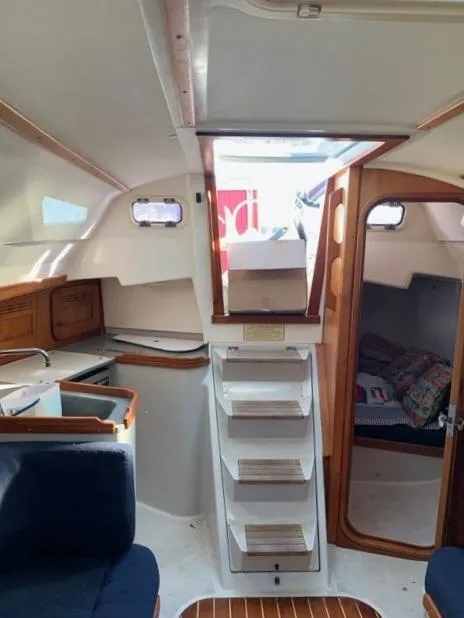 Slide: The Image of Interior of a 2002 C&C 99 sailboat, featuring a compact cabin with wooden accents. - 4