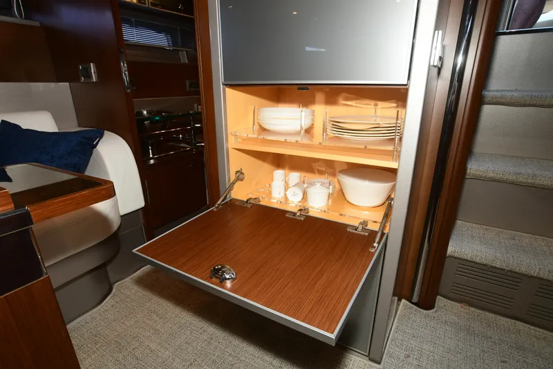 Slide: The Image of Interior of 2012 Riva Rivarama yacht with open cabinet displaying dishes and bowls. - 21