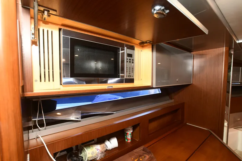 Slide: The Image of Luxurious 2012 Riva Rivarama yacht interior with built-in microwave and wooden cabinetry. - 27