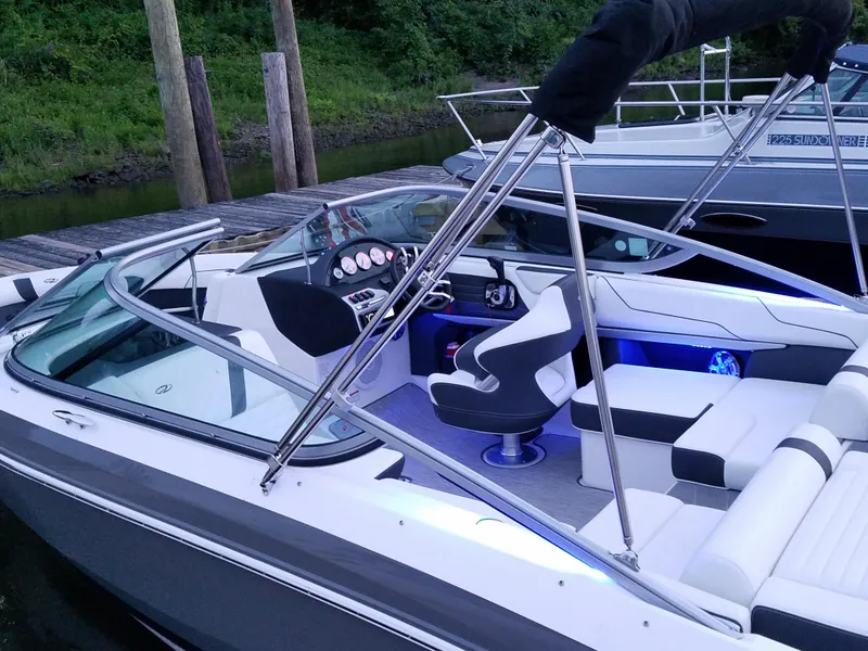 Slide: The Image of 2017 Regal 2100 boat with sleek interior and modern dashboard, docked by a wooden pier. - 11