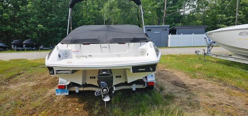 Slide: The Image of 2017 Regal 2100 boat with black cover, parked on grass near trees and a shed. - 15