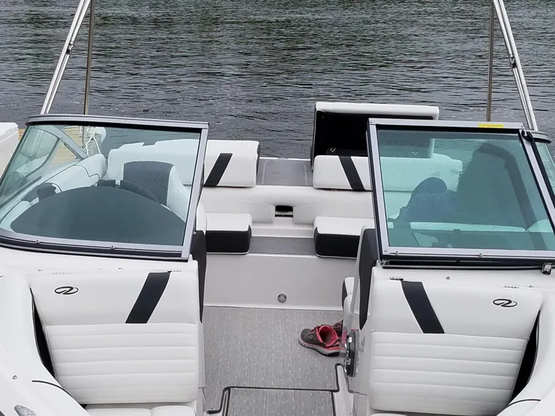 Slide: The Image of 2017 Regal 2100 boat interior with white seating, open windshield, and a single shoe on the floor. - 4
