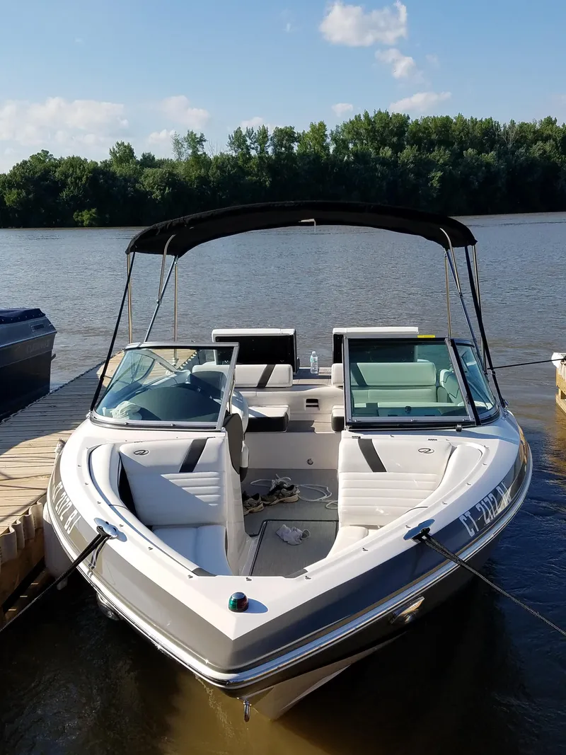 Slide: The Image of 2017 Regal 2100 boat docked on a calm lake with a canopy. - 6