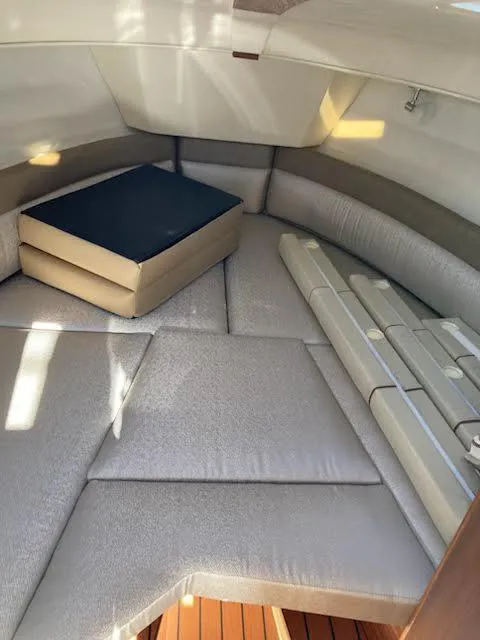 Slide: The Image of 2023 Ranger Tugs R25SC cabin interior with cushioned seating and storage. - 11