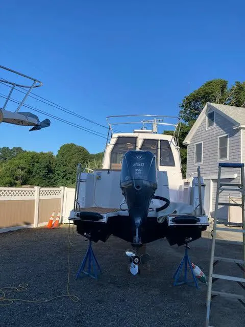 Slide: The Image of 2023 Ranger Tugs R25SC boat on stands, with Yamaha 250 engine, in a residential yard. - 12