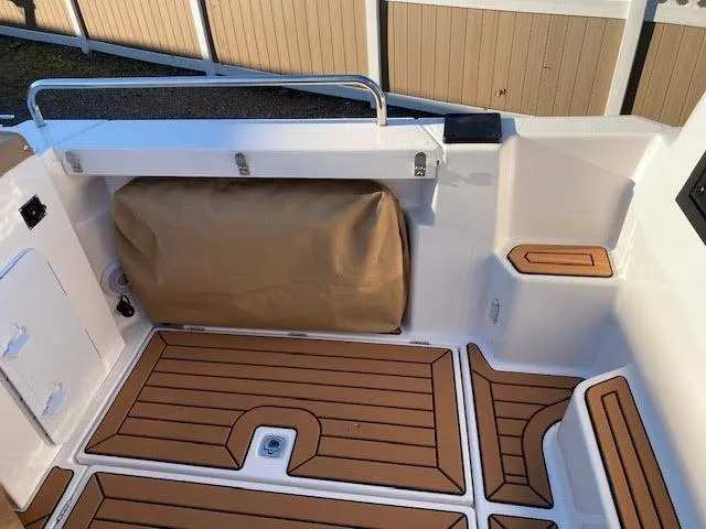Slide: The Image of 2023 Ranger Tugs R25SC boat deck with wood-style flooring and storage compartment. - 4