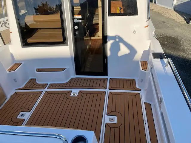 Slide: The Image of 2023 Ranger Tugs R25SC boat deck with teak flooring and modern design. - 6