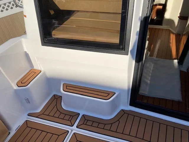 Slide: The Image of 2023 Ranger Tugs R25SC boat interior with wood accents and seating area. - 7