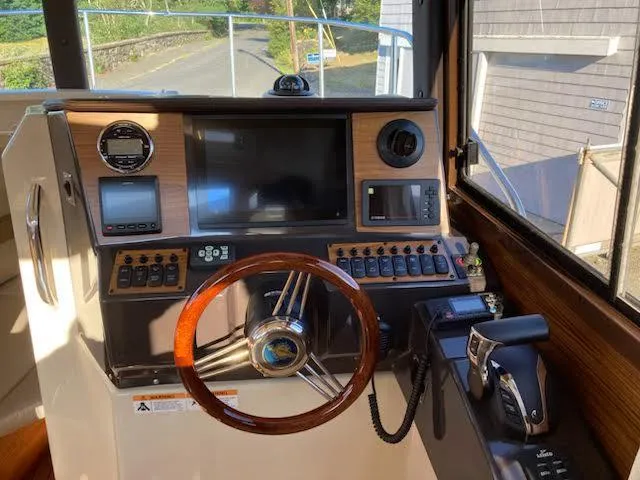 Slide: The Image of 2023 Ranger Tugs R25SC helm with modern controls and wooden steering wheel. - 8