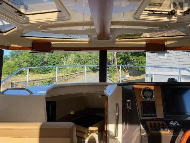 Slide: The Image of 2023 Ranger Tugs R25SC interior with helm, seating, and panoramic windows. - 9