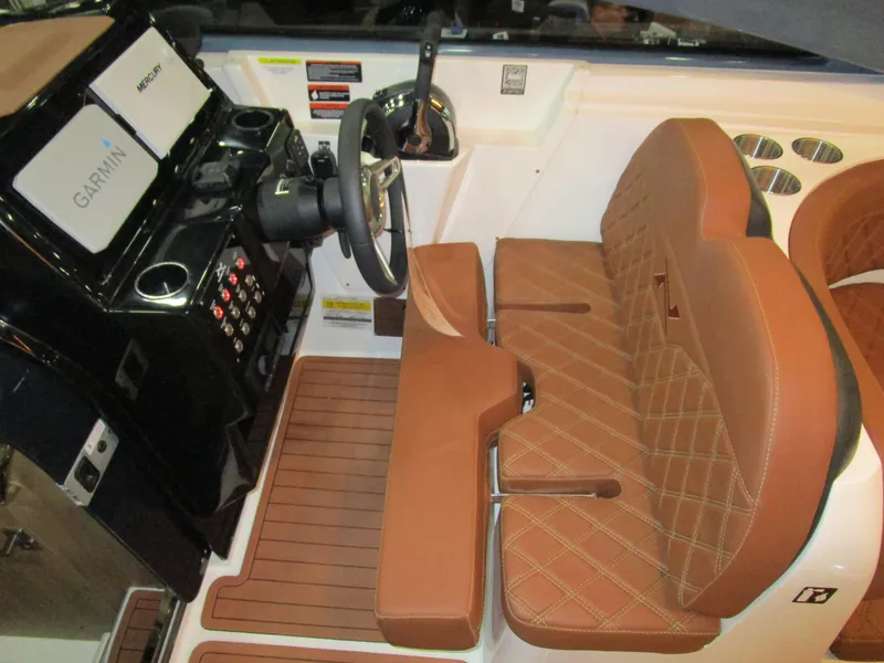 Slide: The Image of 2025 NX Boats N280 XTREME cockpit with brown leather seats and modern controls. - 11