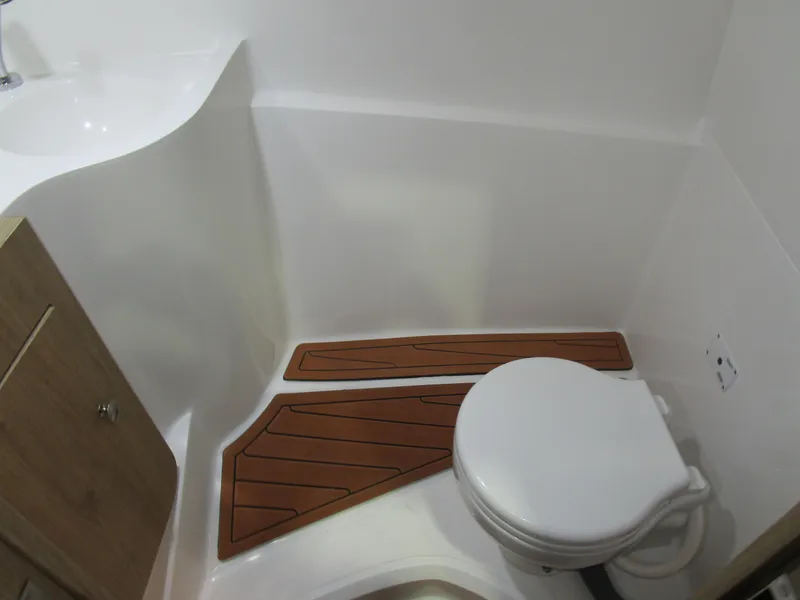 Slide: The Image of 2025 NX Boats N280 XTREME bathroom with modern fixtures and wooden floor accents. - 18