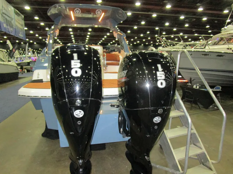 Slide: The Image of 2025 NX Boats N280 XTREME with dual 150 horsepower engines at a boat show. - 4