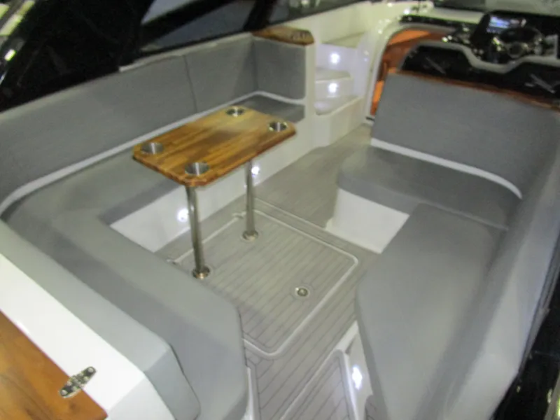 Slide: The Image of 2025 NX Boats 340 Sport Coupe interior with gray seating and wooden table. - 11