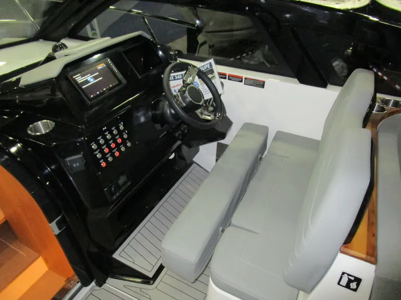 Slide: The Image of 2025 NX Boats 340 Sport Coupe cockpit with modern controls and comfortable seating. - 15