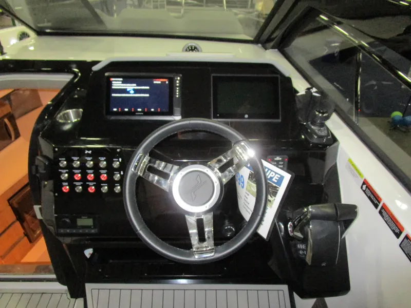 Slide: The Image of 2025 NX Boats 340 Sport Coupe dashboard with modern controls and steering wheel. - 16